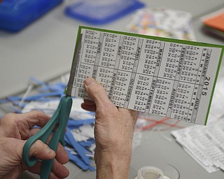 Katie Rickman | The Vindicator.A woman cuts off edges of a calendar bookmark that she and several others have made for veterans  at the Austintown Senior Center on Thursday, Dec. 4, 2014.Mr. Fluffy is an 12-week-old Leonberger dog that spends his days visiting seniors at the center.