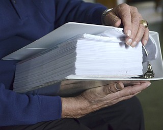 Katie Rickman | The Vindicator.Sam Messina, former human-resource director at Westinghouse Electric Corporation was one of the last to leave the plant when it was shut down in 1985. He still receives phone calls regarding pension checks and such from former employees. Here, he holds a binder containing the third phase of an EPA evaluation in Sharon, PA home on Thursday, Dec. 4, 2014.