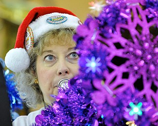 Jeff Lange | The Vindicator  Resident of North Brimfield, Wendy Rose plays her baritone which she decorated with purple snowflakes and lights during Saturday's Tubachristmas concert in Niles.