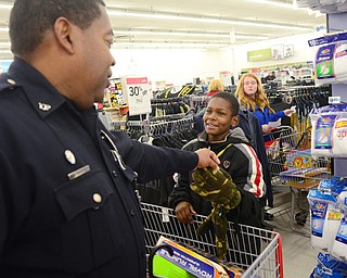 Officer Malik Mostella helps Malik Rowe, 10, of Youngstown find a pair of gloves during Shop with a Cop at Kmart in Boardman on Dec. 6.