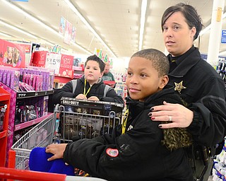 Deputy Olinik helps Larry Smith, 10, right, and Joshua Colvin, 10, left, of Youngstown shop during Shop with a Cop at Kmart in Boardman on Dec. 6. "Honor roll, attendance and great behavior is how they got selected," Deputy Olinik said.