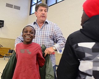 Sam Boak, President of the Canfield Rotary Club, helps brothers Arthur, 9, left, and Ernest Croom, 11, right, pick out a coat from the Salvation Army in Youngstown on Dec. 6. "It's fabulous for the Mahoning Valley," Boak said. "It's great the rotary clubs step up to the plate."