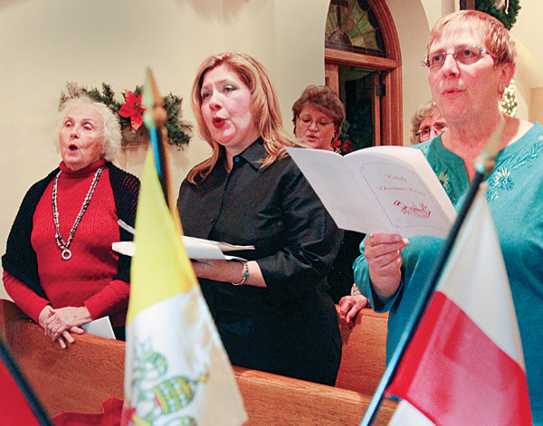 Members of St. Casimir Choir sing traditional Polish carols, koledy, during the culminating segment of the Wigilia, a Christmas vigil, sponsored by the Polish Arts Club of Youngstown at the Brier Hill Cultural Center in Youngstown. From left are Alexandria Copich, Sandra Cika and Ursula Gerchak.