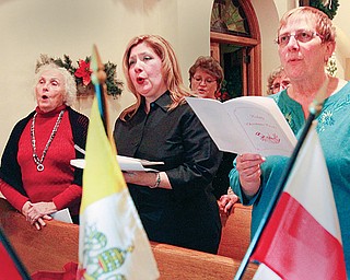 Members of St. Casimir Choir sing traditional Polish carols, koledy, during the culminating segment of the Wigilia, a Christmas vigil, sponsored by the Polish Arts Club of Youngstown at the Brier Hill Cultural Center in Youngstown. From left are Alexandria Copich, Sandra Cika and Ursula Gerchak.