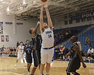 Katie Rickman | The Vindicator.Poland's Jacob Burns (14) goes up for a basket and scores as East's Steven Young (23) attempts to block him during the first period during the game at Poland High School on Tuesday, Dec. 9, 2014.