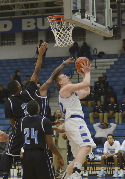 Katie Rickman | The Vindicator.Poland's Dan Black goes up for a shot and is blocked by East's Omon'dre Muhammad (2) and Jawalen Shaw (14) during the first period of the game at Poland High School on Tuesday, Dec. 9, 2014.