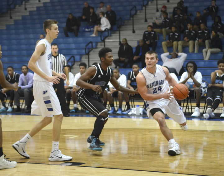 Katie Rickman | The Vindicator.Poland's Austin Wilson pushes past East's Jawalen Shaw before going up for a basket in the first period, Poland's Matt Baker (11) on left looks on during the game at Poland High School on Tuesday, Dec. 9, 2014.