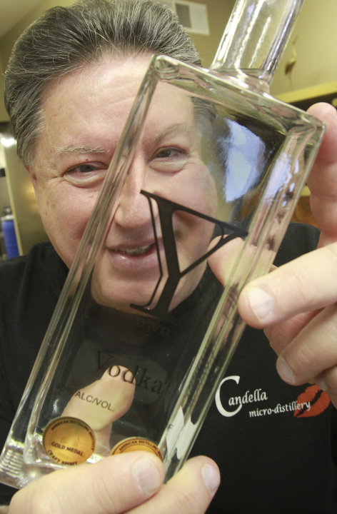 William D. Lewis the vindicator Bill Candella of Candella micro distillery holds a bottle of vodka distilled at the Boardman facility.