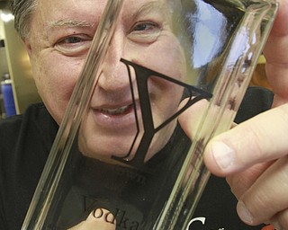 William D. Lewis the vindicator Bill Candella of Candella micro distillery holds a bottle of vodka distilled at the Boardman facility.