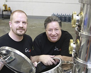 William D. Lewis the vindicator Brothers Chris, left, and Bill Candella of Candella micro pose near the still at their Boardman facility.
