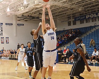Poland’s Jacob Burns (14) scores as East’s Steven Young (23) defends during the first quarter of Tuesday’s game at Poland High School. The Bulldogs won, 73-39.