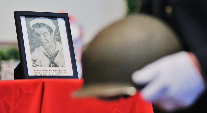 Jeff Lange | The Vindicator  Seen above is a photo of Lucian Sam Biviano SM 1c, as a member of the honor guard walks by with a helmet to honor those who have fallen, Monday morning at the First Presbyterian Church in Warren. Biviano served in the Navy from 1941 to 1945.