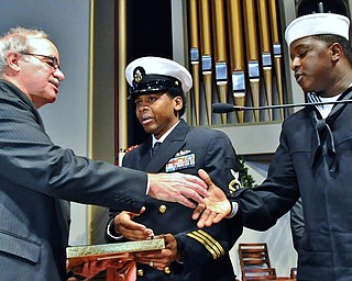 Jeff Lange | The Vindicator  Adrian Biviano (left) shakes the hand of Petty Officer 3rd class Craig Wingate (right) as he receives medals from Chief Jason Hatton (center) on behalf of Lucian Sam Biviano, Monday morning in Warren.