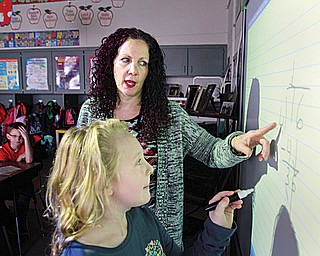 C.H. Campbell fourth-grade teacher Dana Zarlenga-Buist and student Ashleigh Haas, 9, work on a math problem on the new interactive boards in the Canfield classrooms.