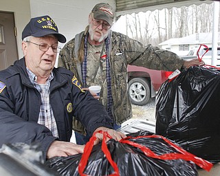        ROBERT K. YOSAY  | THE VINDICATOR..Jim Boehmer comander of  American Legion Post 737 as he and Murle McLaughlin jr... load up the  food baskets for area families. .Canned goods, condiments, bread and boxed dinners line 12 tables inside Lake Milton Presbyterian Church..ItÕs enough to provide 20 families in the Jackson-Milton community with groceries for the holidays. .For nearly 30 years, Murle and Kaye McLaughlin have been organizing the effort to help those in need.