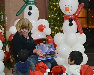 Katie Rickman | The Vindicator.Chris Karis of Struthers reads to a group of Children at the Struthers Christmas event on Thursday, Dec. 11, 2014.