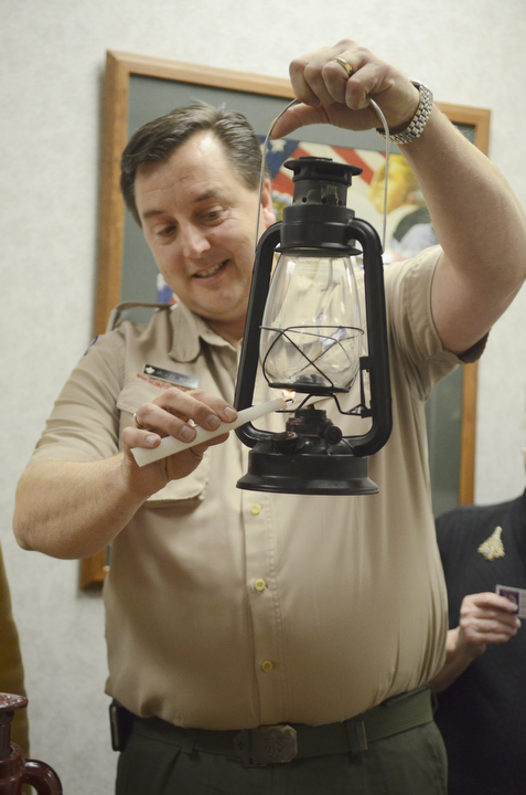 Katie Rickman | The Vindicator.Jason P. Wolf Scout Executive of Boy Scouts of America of Warren lights a lamp with  the flame from the Peace Light that is traveling all over the world from Israel on Friday, Dec. 12, 2014.