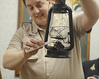 Katie Rickman | The Vindicator.Jason P. Wolf Scout Executive of Boy Scouts of America of Warren lights a lamp with  the flame from the Peace Light that is traveling all over the world from Israel on Friday, Dec. 12, 2014.