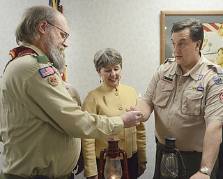 Katie Rickman | The Vindicator.L-R Joe Reding the National Coordinator for The Peace Light, Ginny Pasha President and Chief Executive Officer for the United Way and JAson P. Wolf the Scout Executive of the Greater Western Reserve Council light a candle using the flame from the Peace Light on Friday, December 12, 2014 at the Greater Wester Reserve Council of Boy Scouts in Warren.