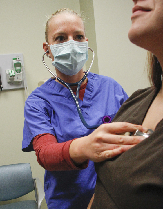        ROBERT K. YOSAY  | THE VINDICATOR. .Upper Respiratory flu.. not covered by the recent flu shots.. is in full swing as PA Physicians Assistan Melissa Morrow.. checks a patient for flu...symptons