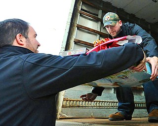 Jeff Lange | The Vindicator  Jason Stouffer of Warren lifts a load of gifts for children into the back of a truck, Tuesday afternoon at the Lordstown GM Plant.
