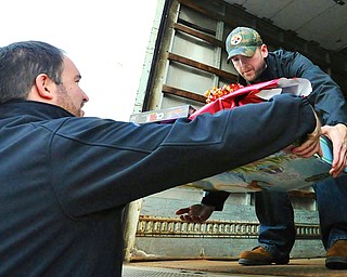 Jeff Lange | The Vindicator Jason Stouffer of Warren lifts a load of gifts for children into the back of a truck, Tuesday afternoon at the Lordstown GM Plant.