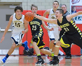Jeff Lange | The Vindicator  Bristol's Alex Jones (21) gets his hand on the ball in front of Zach McMillion (25) and McDonald's Jake Reckard (15) during second half action at Struthers Field House, Saturday night. Devils' Brad Woodley trails the play from behind.