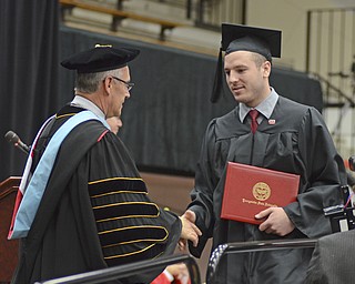 Katie Rickman | The Vindicator.Kory T. Hopkinson shakes the hand of Jim Tressel, President of YSU after receiving his Bachelor of Science in Business Administration degree during commencement at Youngstown State University on Sunday, Dec. 14, 2014 at the Beeghly Center.
