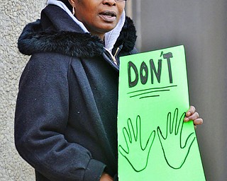 Jeff Lange | The Vindicator  Gina J. Jordan of Warren leans up against the Warren Police Department prior to the start of the group's march down to the courthouse, Saturday afternoon in Warren.