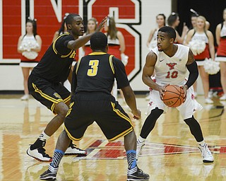 Katie Rickman | The Vindicator.YSU's Marcus Keene (10) looks for an open pass as Kennesaw's Nigel Pruitt (1) on left and Delbert Love (3) guard him during the first half the game at Youngstown State University on Dec. 17, 2014.