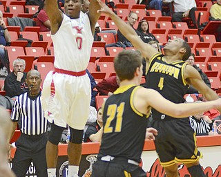 Katie Rickman | The Vindicator.YSU's Shaun Stewart (0) shoots and scores as Kennesaw's  Yonel Brown (4) attempts to block him during the first half the game at Youngstown State University on Dec. 17, 2014.