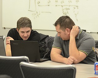 Katie Rickman | The Vindicator.Josh Bakann of Boardman on left and Mike Phillips of Austintown look at a computer during the Code Youngstown meeting at YBI in Youngstown on Tueday, Dec. 16, 2014.