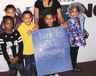 SPECIAL TO THE VINDICATOR: Que Day, above, manager of Club Amazing, is surrounded by some of the children who were recipients of more than 700 coats given for those in need in Youngstown, Lawrence and Mercer counties.
