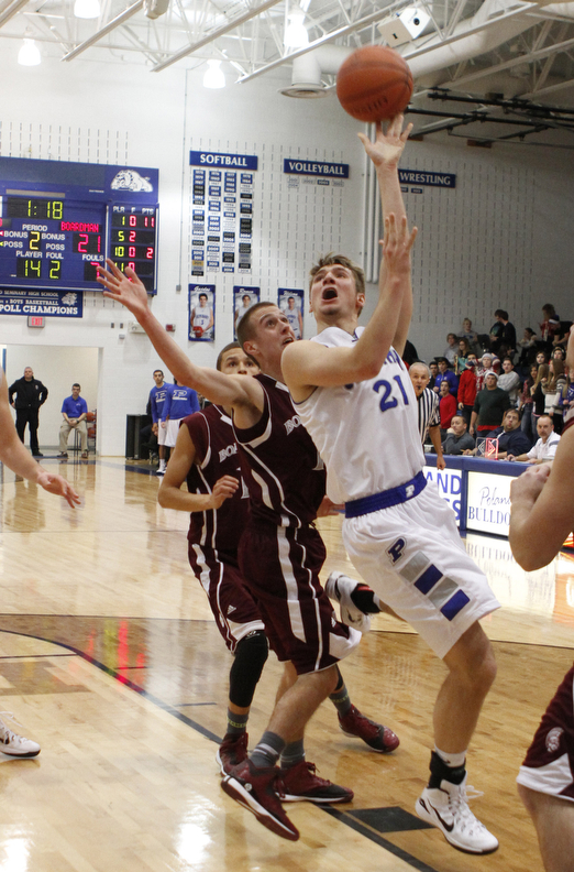 Poland's Kyle Dixon (21) puts up a shot while being defended by Boardman's John Ryan (1) during the first half of Friday nights matchup at Poland Seminary High School. Dustin Livesay  |  The Vindicator  12/19/14  Poland Seminary High School.