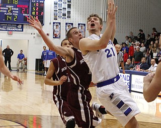 Poland's Kyle Dixon (21) puts up a shot while being defended by Boardman's John Ryan (1) during the first half of Friday nights matchup at Poland Seminary High School. Dustin Livesay  |  The Vindicator  12/19/14  Poland Seminary High School.