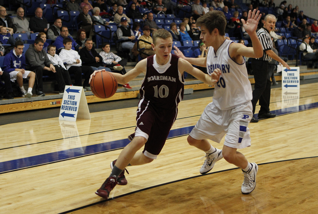 Boardman's Holden Lipke (10) tries to drive to the hoop while being defended by Poland's Mike Gajdos (20) during the second half of Friday nights matchup at Poland Seminary High School. Dustin Livesay  |  The Vindicator  12/19/14  Poland Seminary High School.