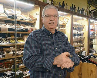 Katie Rickman | The Vindicator.Gino Bellato owner of Havana House in Boardman poses for a photo with a cigar in hand on Wednesday, Dec. 17, 2014.