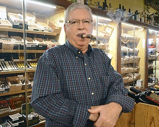 Katie Rickman | The Vindicator.Gino Bellato owner of Havana House in Boardman poses for a photo as he smokes a cigar in his shop on Wednesday, Dec. 17, 2014.