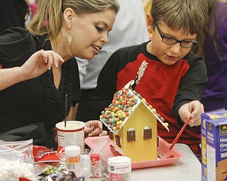        ROBERT K. YOSAY  | THE VINDICATOR..putting on some twizzlers on the outside with aunt Kristine Botak  and Alec Dankovich.. ....gingerbread day at Struthers Elementary! The 4th grade class and their invited guest will be constructing gingerbread houses in the cafeteria...-30-