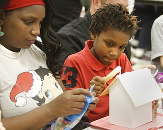        ROBERT K. YOSAY  | THE VINDICATOR.. Demitra Tate and her son Ziere Casey put on the roof of the gingerbread house..gingerbread day at Struthers Elementary! The 4th grade class and their invited guest will be constructing gingerbread houses in the cafeteria...-30-