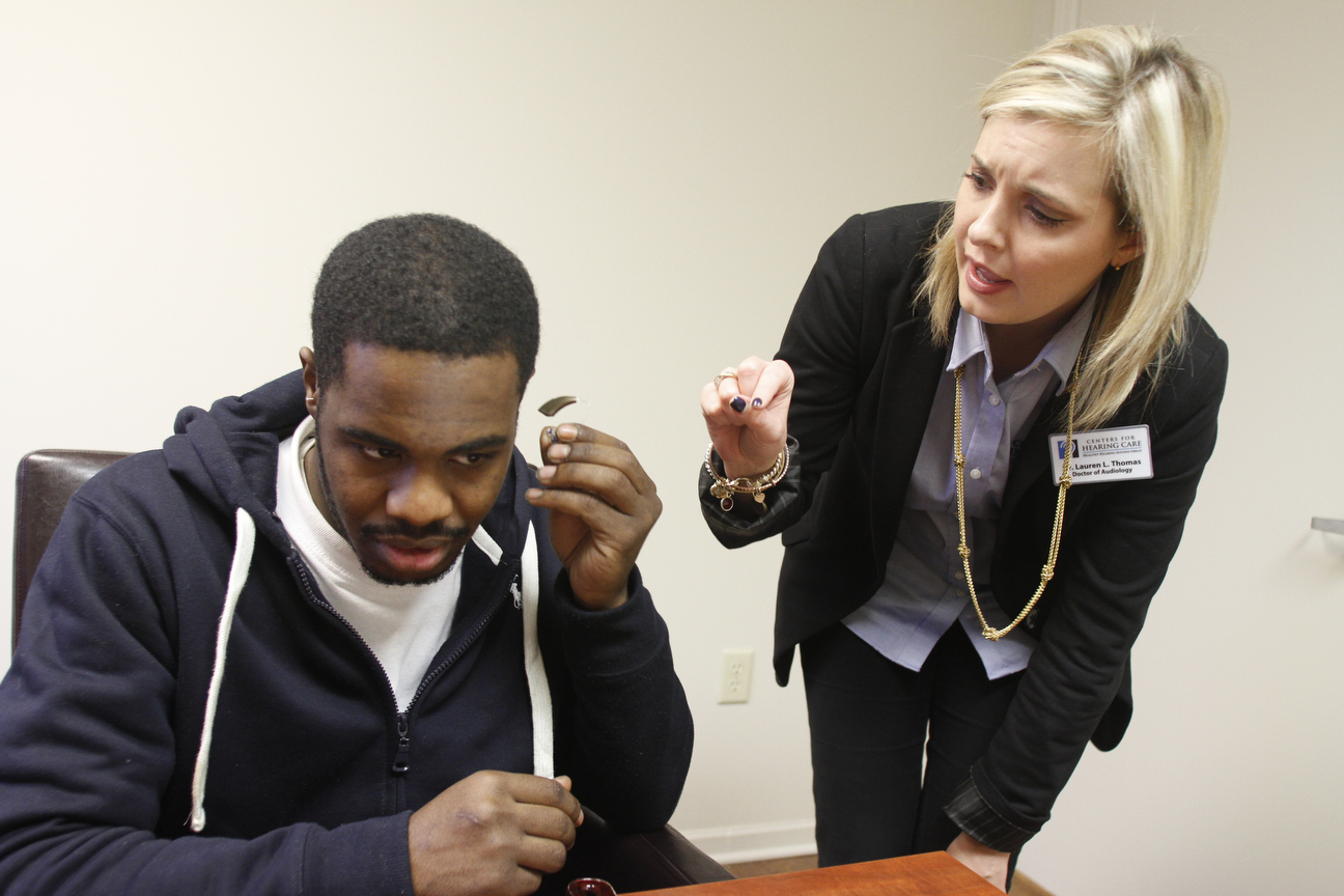        ROBERT K. YOSAY  | THE VINDICATOR..learning how to place his new hearing aid is Louis Burley of Youngstown as Dr  lauren L Thomas explains the technique..at the centers for hearing in boardman .-30-