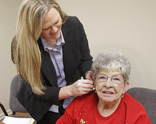        ROBERT K. YOSAY  | THE VINDICATOR..Beverly English of Cortland can hear again... as Dr Amanda Kenney.. adjusts her hearing aid ..at the centers for hearing in boardman .-30-