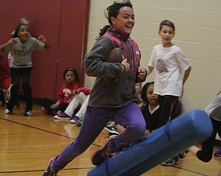Julia Torres jump onto a mat after running with a football during Wllness Day at the W.S. Guy Middle School in Liberty on Wednesday morning.  Dustin Livesay  |  The Vindicator  12/17/14  Liberty.