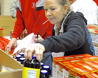 Jeff Lange | The Vindicator  Lynn Colver of K-Mart distribution center and member of the UAW 1112 places grape jelly into someone's box during Wednesday morning's Care and Share food distribution at at the UW Local 1112 Union Hall.