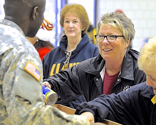Jeff Lange | The Vindicator  Linda St. John of Warren smiles as she places a can of chicken broth into the box of SGT. Joseph Monkam of Austintown (left). Maryola Stemple of Warren looks on from behind.