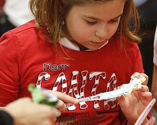        ROBERT K. YOSAY  | THE VINDICATOR..Madalyn Rauzan..puts icing and sprinkles on a star cookie..St. Christine students ( 4th grade )  decorate holiday cookies that will be donated to Youngstown’s Dorothy Day House, which provides emergency shelter and a meal to people down on their luck....-30-