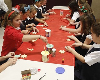        ROBERT K. YOSAY  | THE VINDICATOR..St. Christine students ( 4th grade )  decorate holiday cookies that will be donated to Youngstown’s Dorothy Day House, which provides emergency shelter and a meal to people down on their luck....-30-