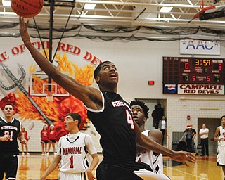 Ray Phifer (4) of Struthers puts up an off-balance layup while being defended by Campbell’s Aaron Jackson (11) in the first half of their game Tuesday in the All-American Conference Blue at Memorial High School in Campbell. The Wildcats downed the Red Devils, 44-33, behind Phifer, who posted 18 points.