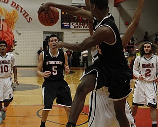 Ray Phifer (4) of Struthers dishes a pass to teammate Andrew Carbon (5) while being closely defended by Campbell Memorial's Jalen Rich (21) during the first half of Tuesday nights matchup at Campbell Memorial High School.  Dustin Livesay  |  The Vindicator  12/23/14  Campbell, Ohio.