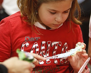        ROBERT K. YOSAY  | THE VINDICATOR..Madalyn Rauzan..puts icing and sprinkles on a star cookie..St. Christine students ( 4th grade )  decorate holiday cookies that will be donated to YoungstownÕs Dorothy Day House, which provides emergency shelter and a meal to people down on their luck....-30-